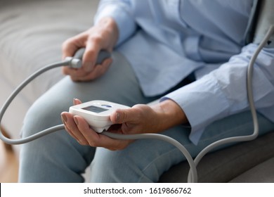 Close Up Older Woman Checking Blood Pressure With Digital Tonometer At Home, Mature Female Holding In Hands Medical Electronic Device, Cardiovascular Chronic Disease Treatment And Self Control