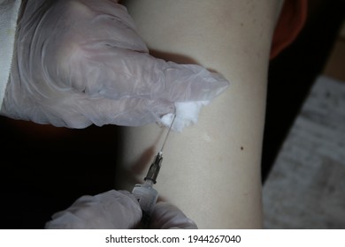 Close Up Of Older Woman Getting Injected With A Vaccine In Upper Arm.