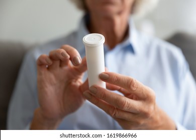 Close Up Older Woman Holding White Plastic Bottle With Pills In Hands, Reading Instruction Or Prescription, Mature Female Preparing To Take Medicine, Chronic Disease, Healthcare And Treatment Concept