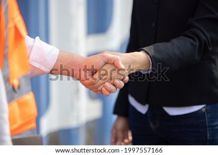 Close Up on Asian Worker Having a Hand Shake with His Female Manager at Container Cargo Site