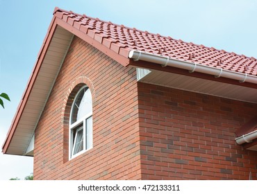 Close Up On Attic Brick House Roof Construction With Ceramic Tiles
