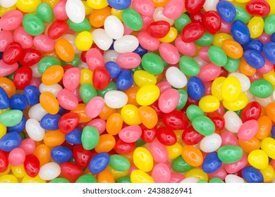 Close up on background of bright vibrant colorful jelly beans, wood spoon comes in and scoops up some candy. - Powered by Shutterstock