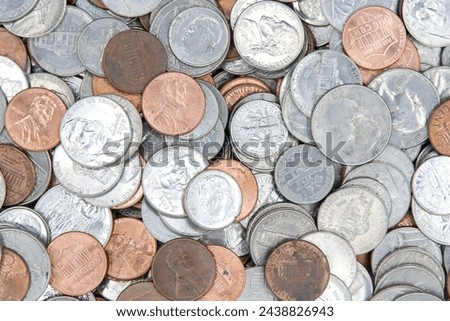 Close up on background of dirty American coins laying on a flat surface. Quarters, dimes, nickels and pennies.