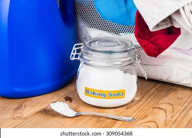 Close Up On Baking Soda With Detergent And Pile Of Dirty Laundry