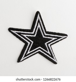 Close Up On A Black Star Fabric Patch On White Background. Hand Craft Supplies To Refashion Your Old Clothes.