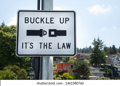 Close up on a "Buckle Up. Its The Law" sign  for wearing a car seatbelt, in a transportation background