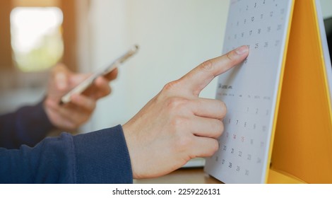 close up on businessman hand using pen to writing schedule on calendar 2023 to make appointment meeting or manage timetable each day at house for work from home concept	 - Shutterstock ID 2259226131