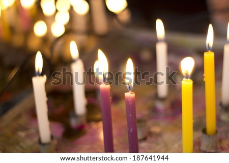 Close up on the candle of an improvised chapel's altar.