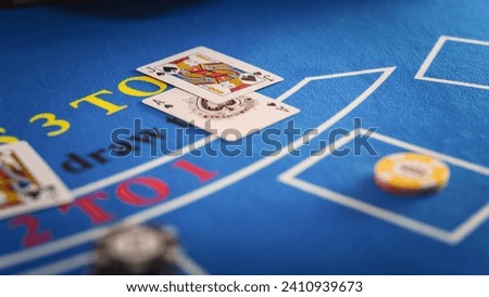 Close Up on Casino Baccarat Gambling Table: Anonymous Croupier Dealing Playing Cards on a Blackjack Table with Bet Chips in Place. Poker Chips are Being Exchanged as the Lucky Guest Wins the Jackpot