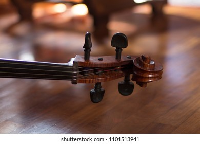 Close Up On A Cello Tuning Keys, Background Is A Wooden Parquet Floor