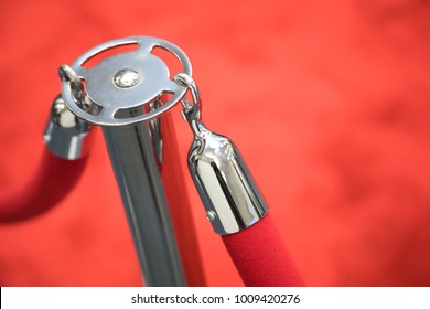 Close up on chrome clip and stanchion with red velvet ropes and formal red carpet background - Shutterstock ID 1009420276