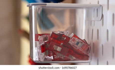 Close Up On Clips Stored Inside A Clear Box Hanging From Peg Board As A Storage Idea For Craft Room Or Workshop Wall