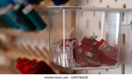 Close Up On Clips Stored Inside A Clear Box Hanging From Peg Board As A Storage Idea For Craft Room Or Workshop Wall