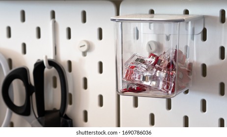 Close Up On Clips Stored Inside A Clear Box Hanging From Peg Board As A Storage Idea For Craft Room Or Workshop Wall