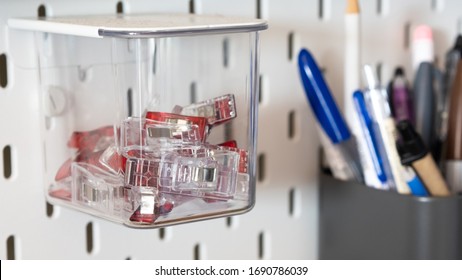 Close Up On Clips Stored Inside A Clear Box Hanging From Peg Board As A Storage Idea For Craft Room Or Workshop Wall