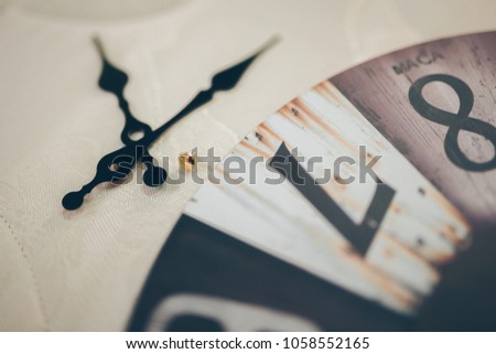 Close up on clockwise.face of vintage. The clock in the hard sunset light. And have clockwise on top watch. and have shadow. And have big number of time. This Image is abstract style.