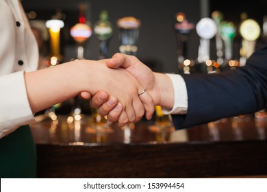 Close Up On Colleagues Shaking Hands During Meeting In A Classy Bar