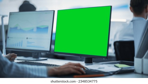 Close Up on Computer Monitor Green Screen Display in a Business Office. Male Financial Data Analyst Using Laptop And Studying Information And Graphs On Big Digital Screen In Monitoring Office - Powered by Shutterstock