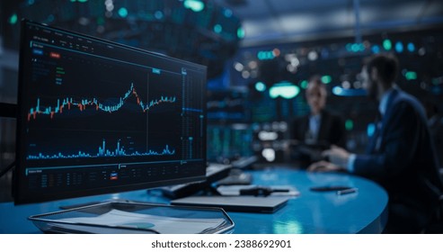 Close Up on a Computer Screen with Real-Time Stock Market Analytics, Graphs and Reports. Stock Exchange Software Template. Brokers Discussing Financial and Business Opportunities in the Background - Powered by Shutterstock