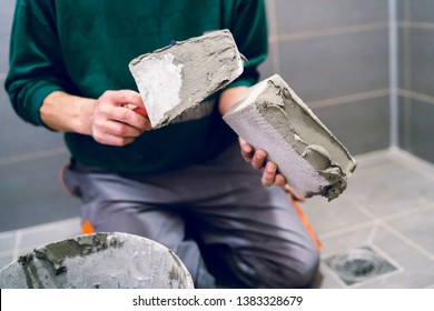 Close Up On The Construction Worker Applying Adhesive Cement Material To The Brick Block Building Wall In The Bathroom