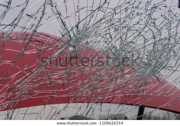 Close up on cracked\
windshield of red car
