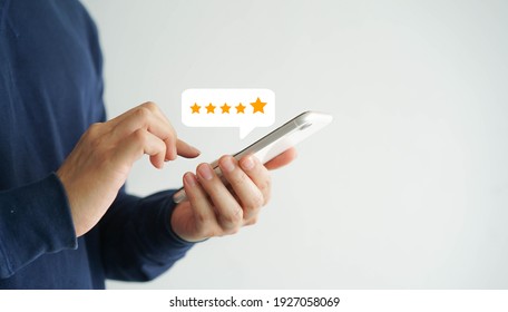 close up on customer man hand pressing on smartphone screen with gold five star rating feedback icon and press level excellent rank for giving best score point to review the service , business concept - Shutterstock ID 1927058069