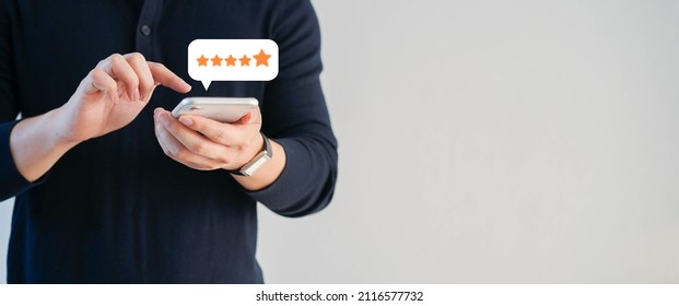 close up on customer man hand pressing on smartphone screen with gold five star rating feedback icon and press level excellent rank for giving best score point to review the service , business concept - Shutterstock ID 2116577732