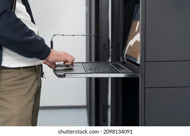 Close up on Data Center Engineer hands Using keyboard on a supercomputer Server Room Specialist Facility with Male System Administrator Working with Data Protection Network for Cyber Security.