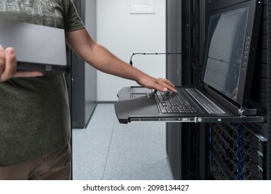 Close up on Data Center Engineer hands Using keyboard on a supercomputer Server Room Specialist Facility with Male System Administrator Working with Data Protection Network for Cyber Security.