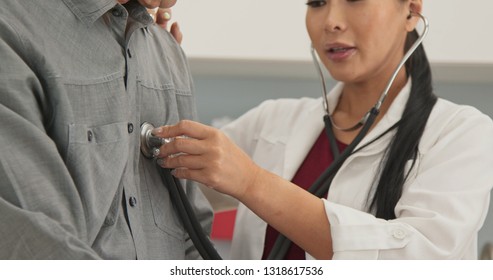 Close Up On Doctor With Bedazzled Nails Listening To Older Male Patient Breathing And Heart Through Stethoscope On His Chest