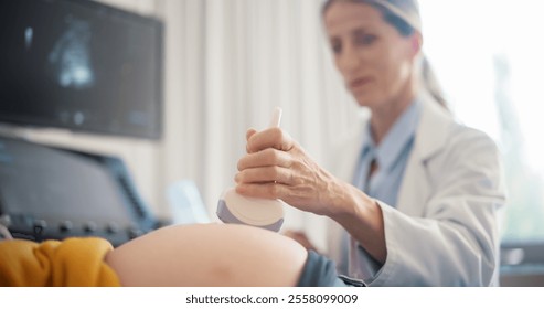 Close Up on Doctor's Hand Using Advanced Ultrasound Equipment to Examine a Pregnant Woman, Explaining Details About the Fetus. Excited Female Patient Smiling as She Sees the Baby’s Image on Display