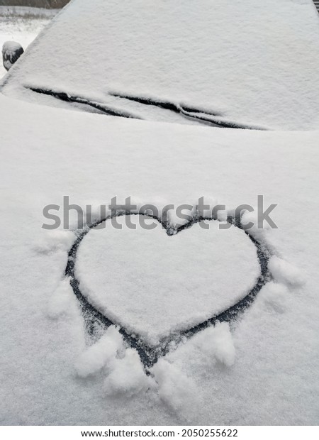 close\
up on drawing hearts on car windshield after\
snow