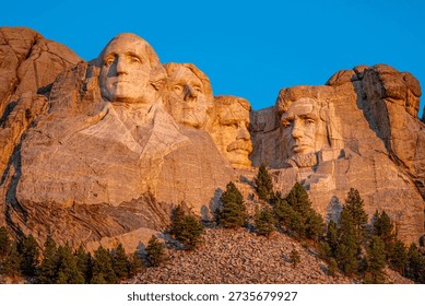 Close on the faces of Mount Rushmore struck by the golden rays of the sunrise, South Dakota