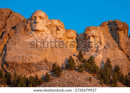 Close on the faces of Mount Rushmore struck by the golden rays of the sunrise, South Dakota