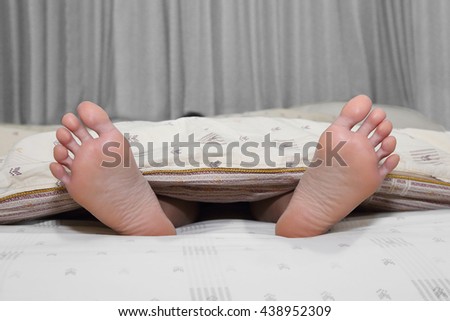 close up on feet cover in a bed duvet