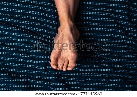 Close up on the feet of a young woman lying in bed