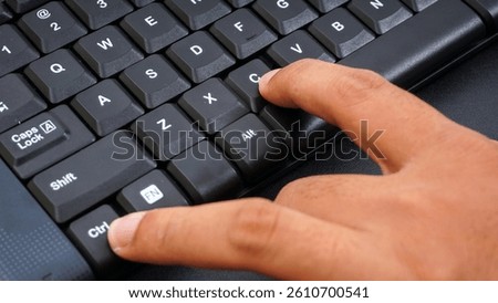 Close up on finger pressing ctrl or control and c or ctrl + c shortcut keys on a computer keyboard for copy isolated on black background