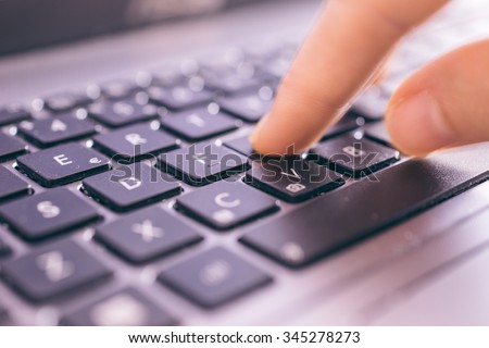 Close up on fingers texting on a computer keyboard