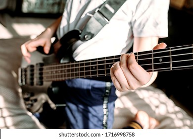 Close Up On The Fingers Of Young Girl Playing Bass Guitar