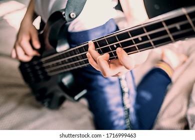 Close Up On The Fingers Of Young Girl Playing Bass Guitar