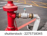 Close up on a fire hose connected to a red water hydrant.