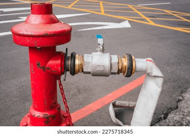Close up on a fire hose connected to a red water hydrant.