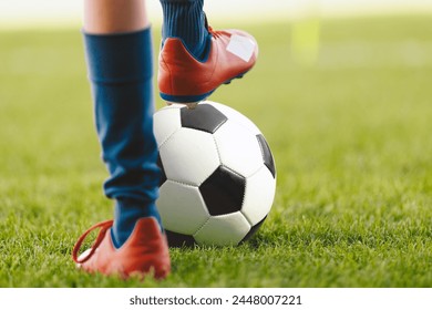 Close Up on Football Player Kicking Ball on Sunny Day. Soccer Boy Running in White Cleats on Grass Pitch. Sports Soccer Low Angle Background - Powered by Shutterstock