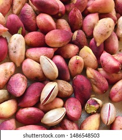 close up on fresh pistachios , some of the with pink and yellow husks - Shutterstock ID 1486548503