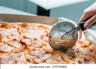 Close Up On Fresh Tasty Whole Baked Pizza With Bacon And Cheese On The Table Hand Of Unknown Caucasian Woman Cutting Hold Cutter Roller Blade Wheel Rolling Over