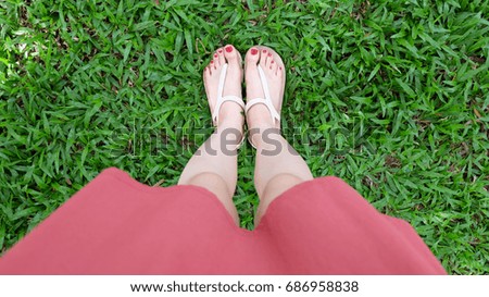 Close Up on Girl's Feet Wearing Sandals on Green Grass Great For Any Use.