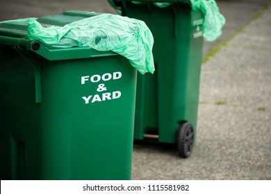 Close Up On A Green Food Scrap And Yard Waste Compost Bin, Curbside For Garbage Day Pickup, With Space For Text On Right