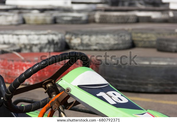Close up on green go kart and\
steering wheel on racing circuit park. Motor sports\
concept