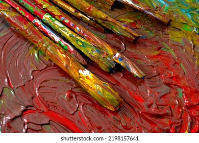 Close up on grungy paint brushes on messy artist canvas covered with oil paints conceptual representation for fine art gallery, visual artistic genius and talented painter's workshop - Powered by Shutterstock