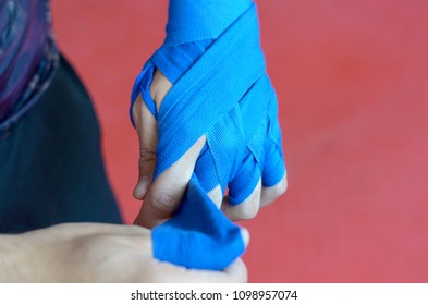 Close Up On The Hand Of A Boxer Wearing Blue Bandages Wrapped Around His Hand To Protect His Knuckles And Wrist